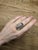 A pink tourmaline rests in a vibrant pink at the heart of this solid 14K white gold ring, encircled by thirty-six earth-...