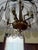 Striking vintage 1970s Hollywood Regency chandelier featuring a brass-tone frame adorned with faceted smoked glass prism...