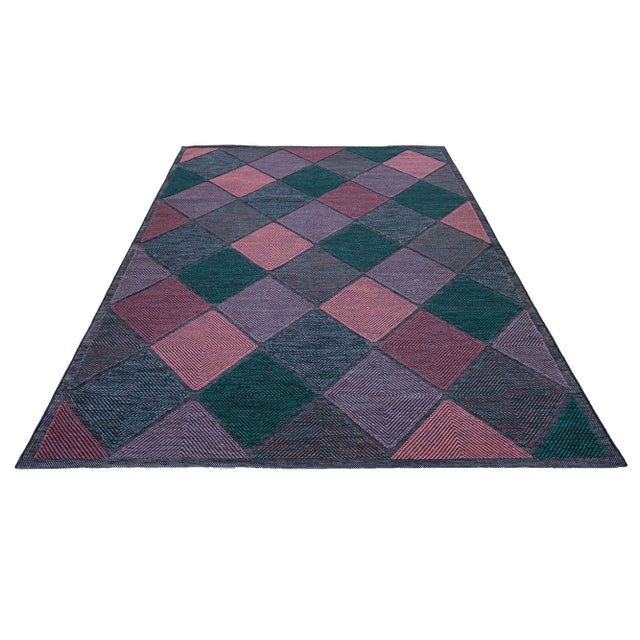 This flatweave rug showcases a contemporary Swedish design with a gray base. It's accented with green, purple, and pink...