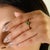 This elegant solitaire engagement ring features a round-cut emerald weighing approximately 0.47 carats, set in rich 14K...