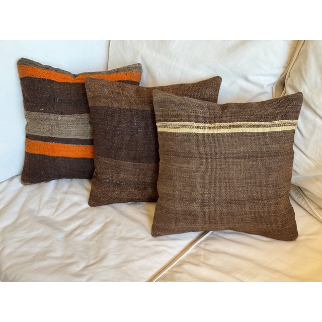 Three pillows of similar tone and design. All custom made from old Turkish kilims. Filled with new clean synthetic material.