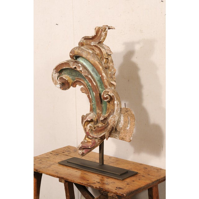 An Italian carved and gilt wood fragment from the 18th century, presented on custom stand. This antique decoration from...