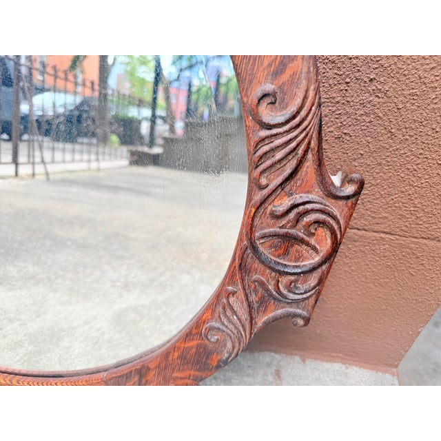 Early 20th century Victorian Arts & Crafts style oval wall mirror crafted in solid quarter sawn tiger oak. The frame...