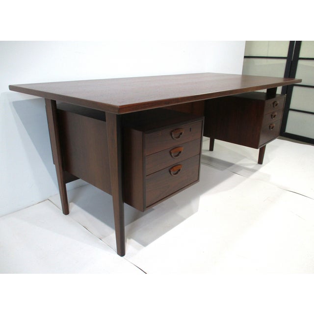 An exceptionally stunning Brazilian rosewood executive desk with floating top, three drawers to each side and to the...