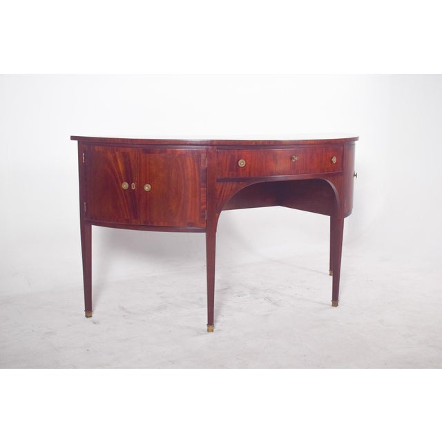 Empire sideboard in the shape of a half-moon. with a varnished finish in a reddish tone, it shows off precise and elegant...