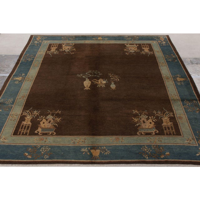 An antique Peking rug originating from China circa 1920-1930. Hand-knotted wool, the 8x9 rug exhibits exemplary Chinese...