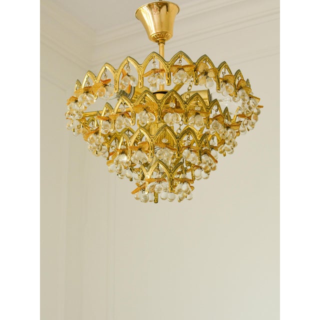 An exceptional and wonderfully decorative vintage chandelier featuring 58 genuine Murano glass fruit crystals arranged...
