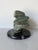 A striking 1980s vintage abstract sculpture hand-carved from richly veined green marble and displayed on a polished black...