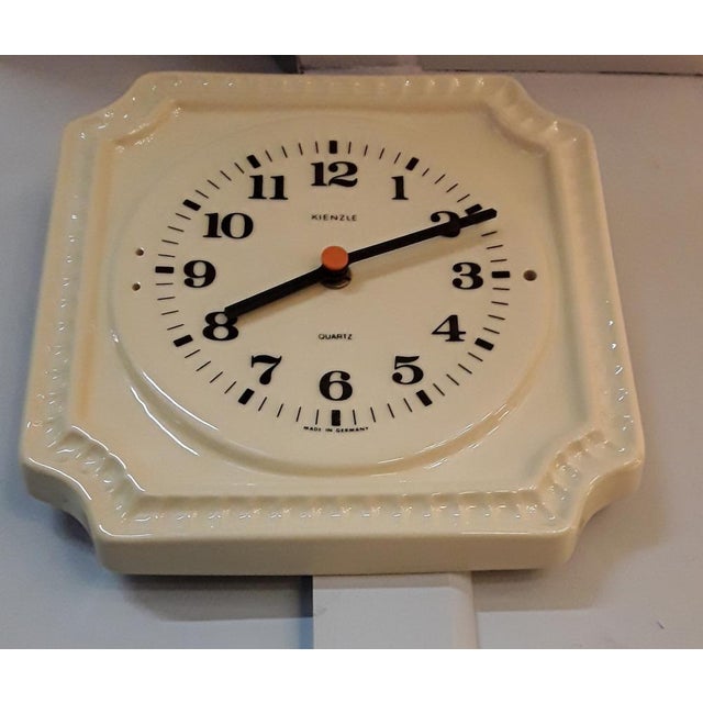 Vintage German Wall Clock in Cream-Colored Ceramics with Black Hands and Digits with Orange Point from Kienzle, 1970s, in...