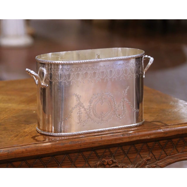 Crafted in England in the mid-20th century, this elegant silver-plated wine bottle holder by International Silver Co....