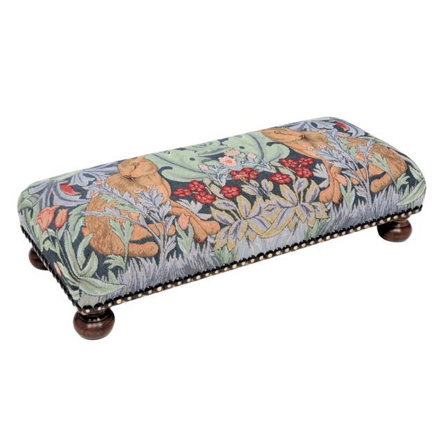 Meticulously handcrafted in the United Kingdom, this upholstered stool boasts classic studding and hand-polished solid...
