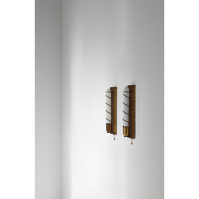 Pair of rare Art Deco wall lamps in patinated brass and tubular light bulbs made in Denmark in the 1940s. In the style of...