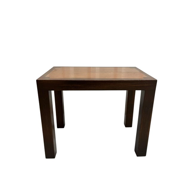 A handsome vintage mid-century modern small side table featuring a rich, dark wood frame, clean architectural lines, and a...