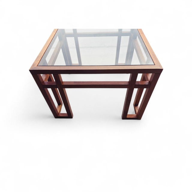 A sculptural Danish modern side table crafted in solid teak, featuring an architectural open-frame base with subtle angled...