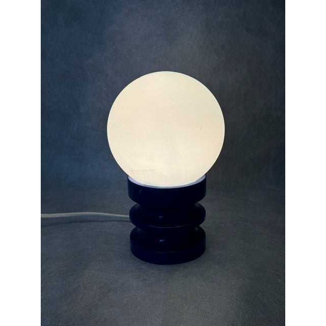 German Space Age table lamp from the 1970s featuring a spherical opaline glass shade set on a sculptural stepped blue...