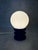 German Space Age table lamp from the 1970s featuring a spherical opaline glass shade set on a sculptural stepped blue...