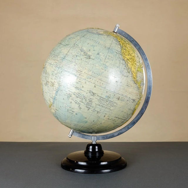 This relief globe sitting on a dark brown base Bakelite. The meridian is made of metal. The ball was made of cardboard...