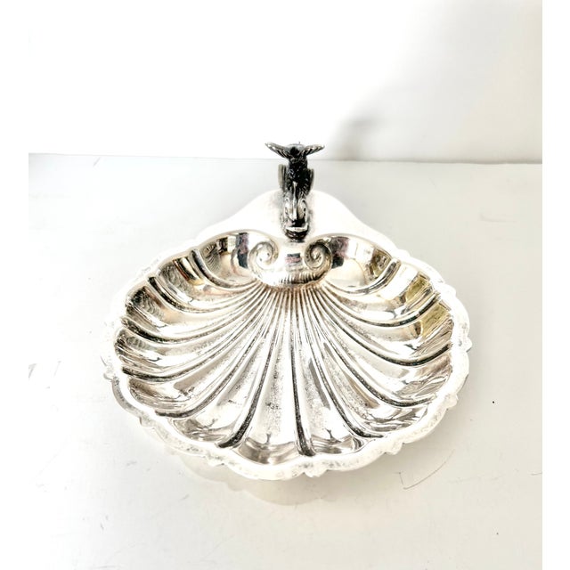A striking vintage silverplate shell dish by Gorham featuring a beautifully sculpted figural fish handle rising from the...