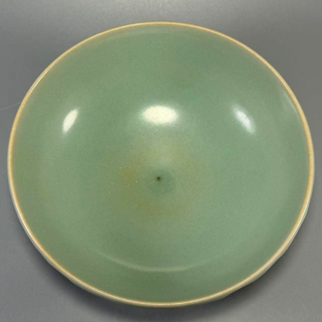This antique Chinese Longquan celadon bowl is decorated with carved lotus petal patterns on the exterior. It features...