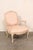 A French pair of carved-wood and upholstered Louis XV style armchairs from the mid 20th century. This vintage pair of...