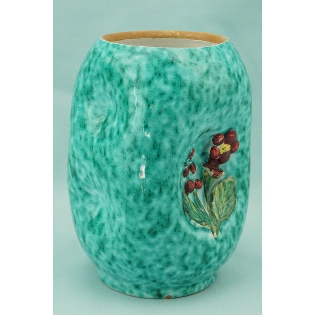 A stunning majolica vase, with hand-crafted bulges enriched with bas-relief floral decorations, entirely hand-modeled on a...