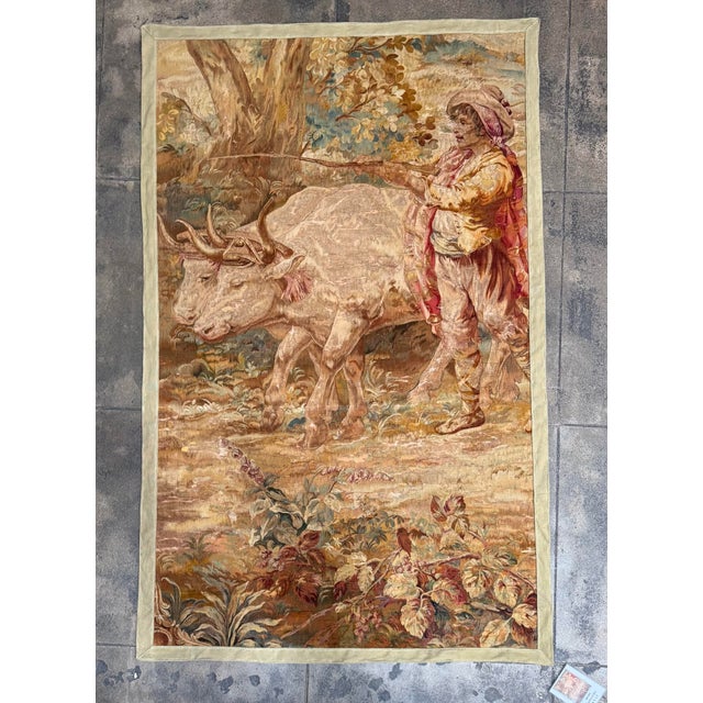 A rare and highly decorative 17th century Brussels tapestry depicting a pastoral rural scene with a peasant guiding two...