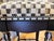 MacKenzie-Childs vintage counter stool. Upholstered in the traditional black/white Courtly Check fabric, braiding and nail...