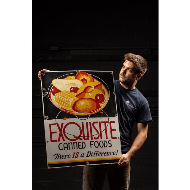 Vintage single-sided porcelain sign advertising "EXQUISITE" canned foods. It is unknown if this is advertising a...