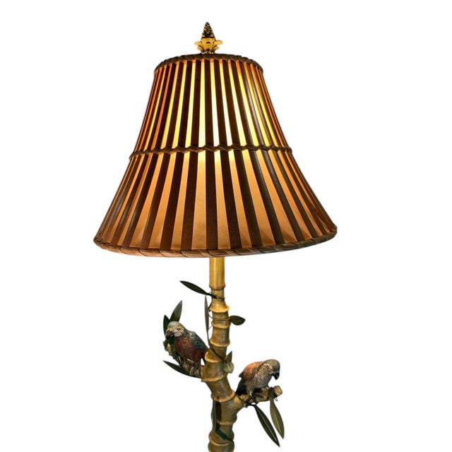 Rare, hand painted parrot adorned floor lamp. Has a bamboo shade with a rose gold interior fabric. Lamp stands 61” tall...