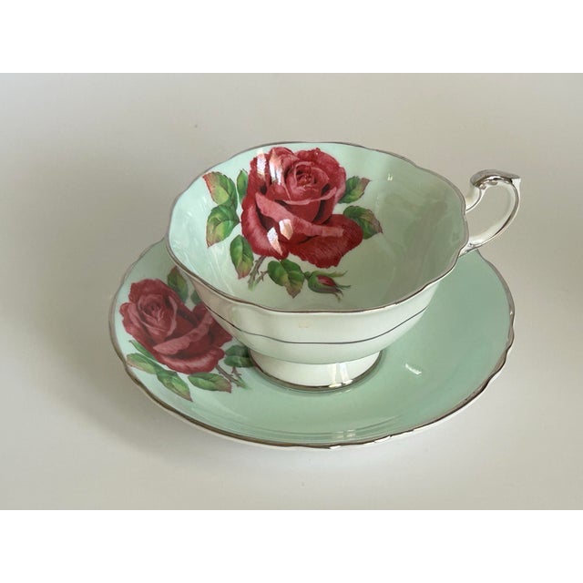 A charming vintage Paragon teacup and saucer in fine English bone china, decorated with generous red-pink cabbage roses...