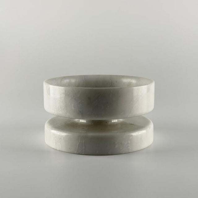 Iconic centerpiece / pedestal bowl designed by Angelo Mangiarotti in the 1970s, executed in solid white Carrara marble. A...