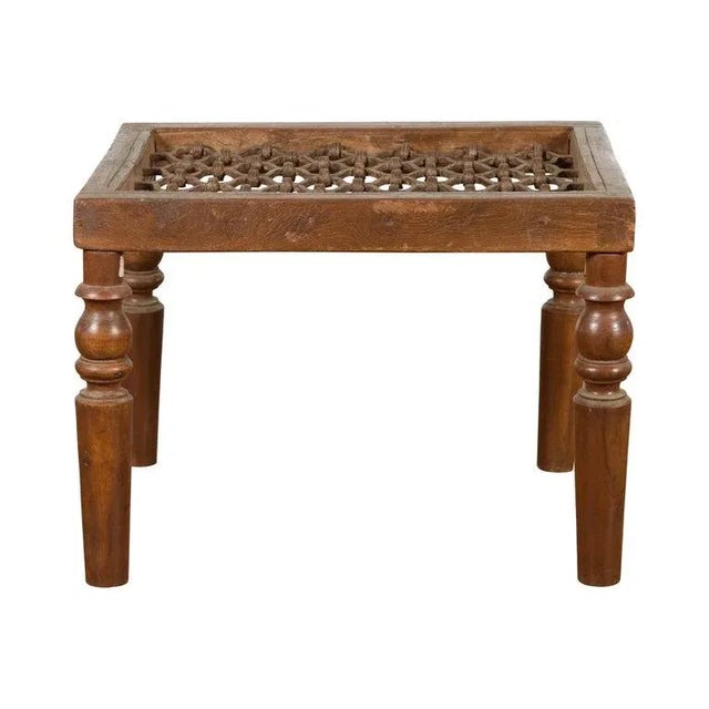 An antique rustic Indian window grate from the 19th century, made into a coffee table with baluster legs and weathered...