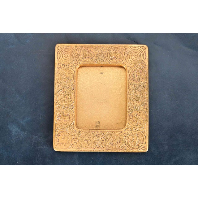 A gorgeous Art Deco or Arts & Crafts period gilt bronze picture frame featuring symbols of the Zodiac By Tiffany Studios...