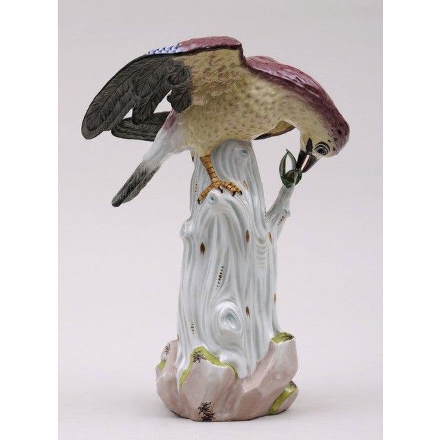 Dresden porcelain bird perched on a tree stump eating leaves painted in mauve, blue, black, cream and gray. Painted by...