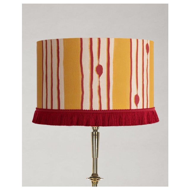 A tribute to the rhythmic essence of Pat Metheny’s Minuano, this drum drum-shaped shade decorated with red cotton fringes...