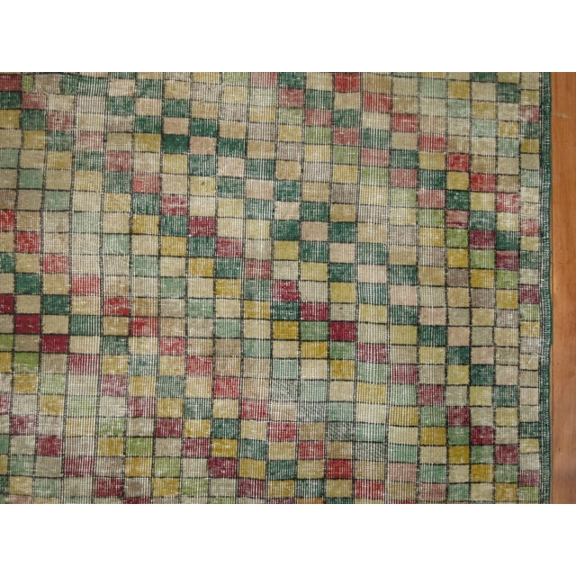 Distressed room-size Turkish deco rug with a repetitive square design throughout in multiple colors, predominantly in...