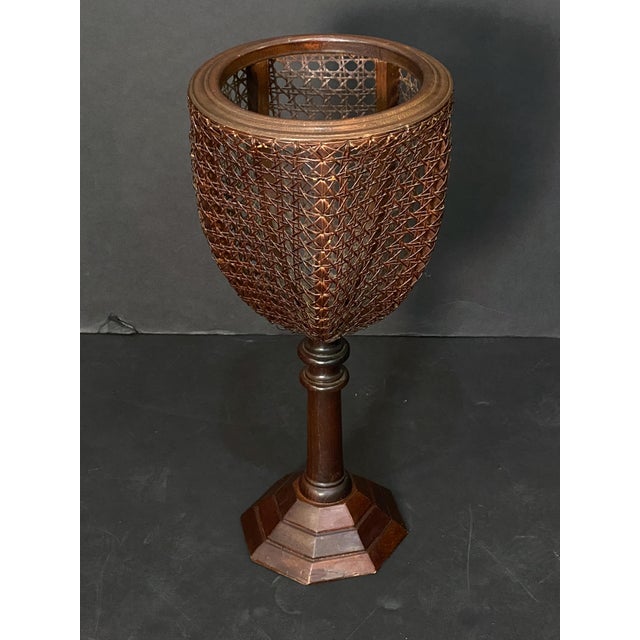 A fine English plant stand or jardiniere from the Edwardian era, featuring a cane (wicker) basket with a goblet or...