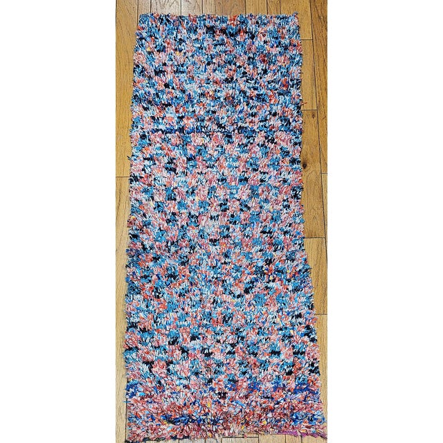 This vintage Moroccan Boucherouite runner is a vibrant work of folk artistry and sustainable craft — handwoven entirely...