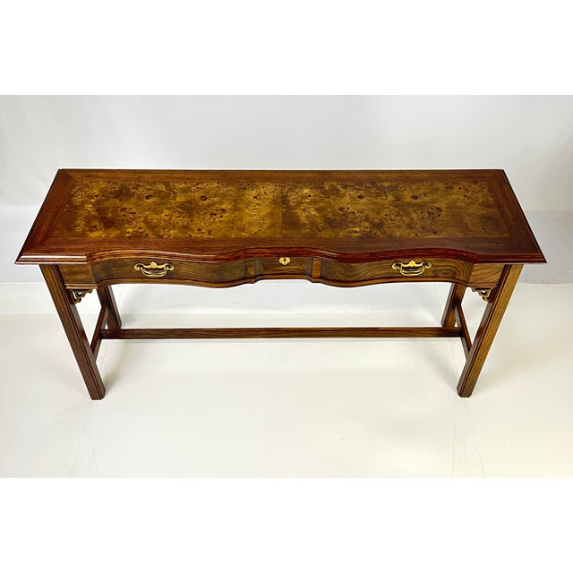 Vintage console table showcasing traditional craftsmanship and striking wood grain. The piece features an elegant...