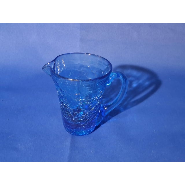 This hand blown sapphire blue glass miniature pitcher was produced by the Pilgrim Glass Co. from Ceredo, W.V, and they...