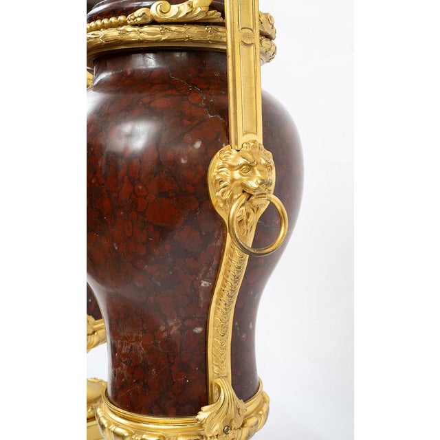Pair of Napoleon III-style red griotte marble vases with handles, featuring inlays of finely chiseled gilded bronze...
