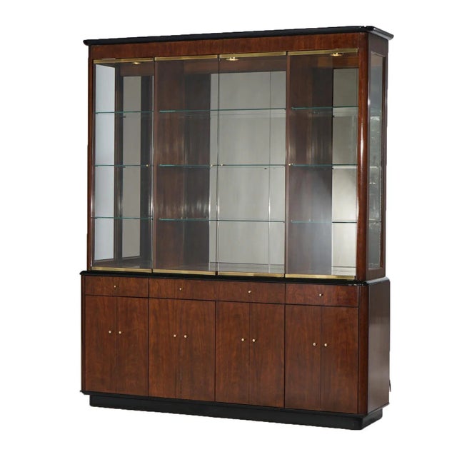 A Mid Century Modern breakfront cabinet by Drexel of the Profiles line offers glass upper over mahogany and ebonized...