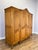 An elegant Vintage French Louis wardrobe in Oak, featuring a warm natural finish, four panelled doors, decorative carved...