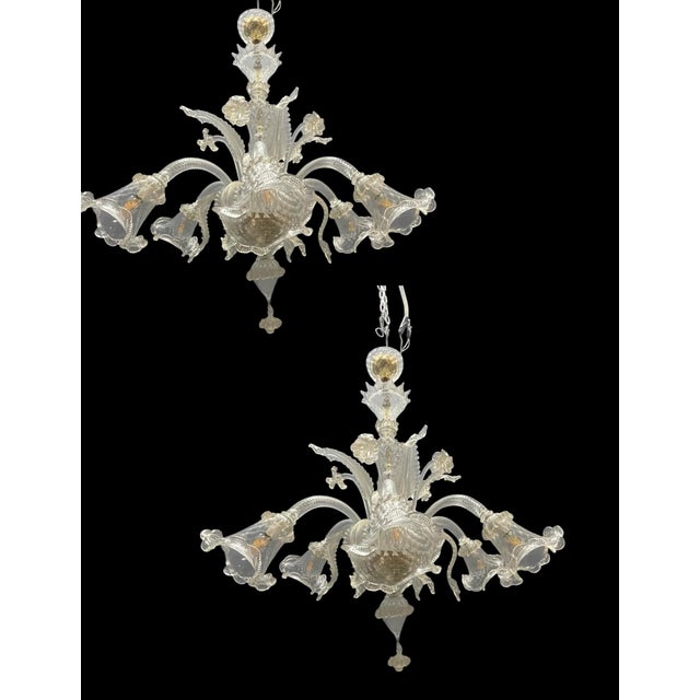 Exceptional pair of large Venetian chandeliers handcrafted in Murano, Italy, featuring elegant transparent mouth-blown...