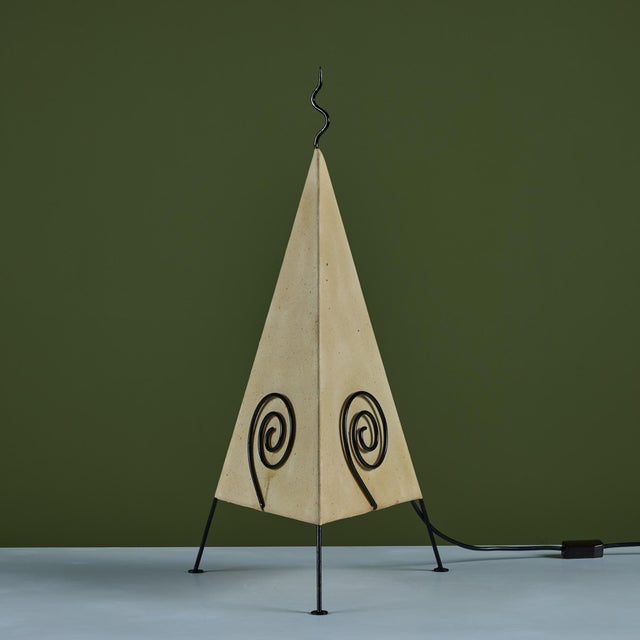 Tripod postmodern paper shade table lamp with black enameled frame. The table lamp showcases a triangular paper shade with...
