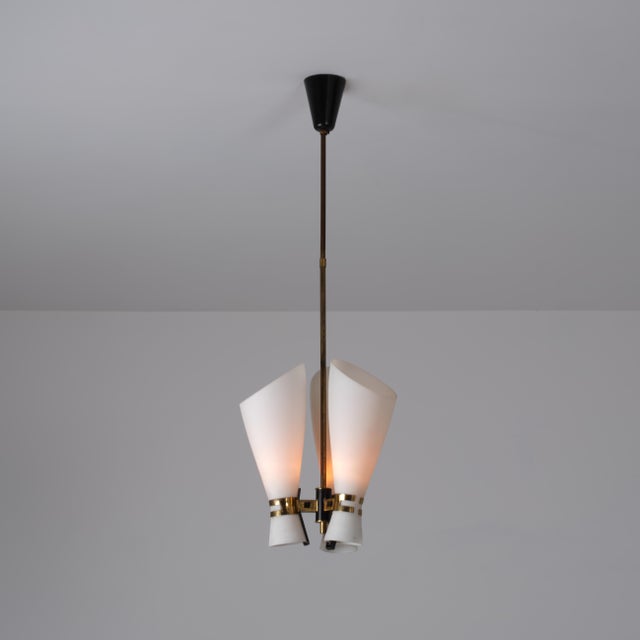 Italian three-light pendant dating from the 1950s, characterized by a refined mid-century composition and a balanced...