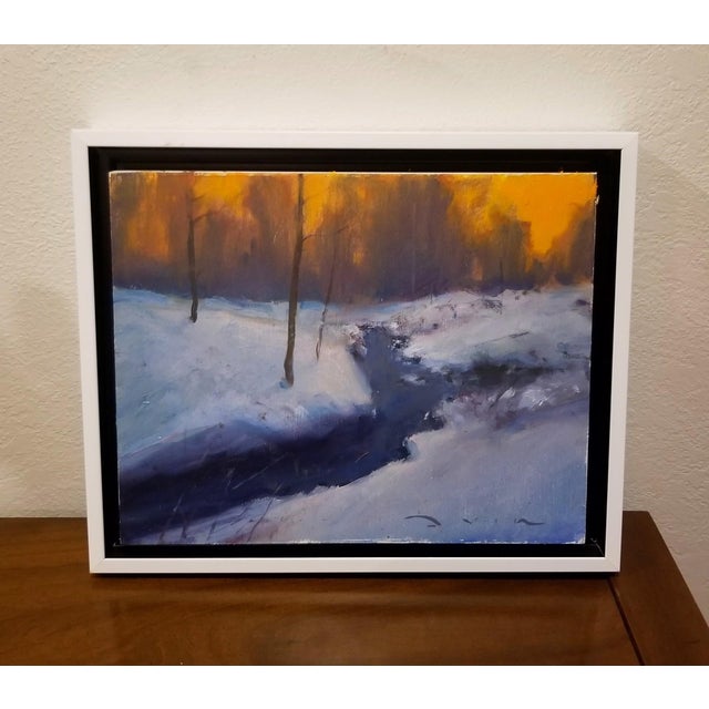 In "Winter Solace," a tranquil winter landscape unfolds with a meandering stream cutting through a blanket of snow. The...
