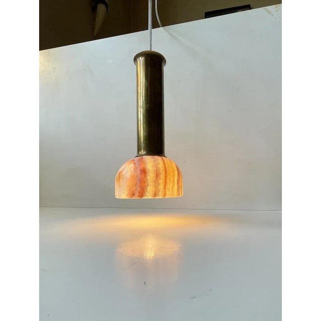 A small and possibly bespoke hanging light composed of a turned onyx marble shade an over-sized top in solid patinated...