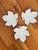 These are white porcelain leaf-shaped dishes with a glossy finish. The leaves have detailed veining and a small loop-like...