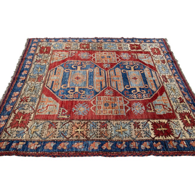 This Kazak wool rug is handcrafted with great attention to detail. It features a rich red palette with delicate blue,...